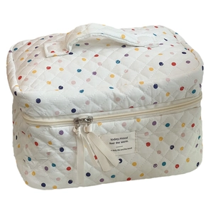 Quilted white cotton makeup bag with colorful polka dots and a sturdy top handle
