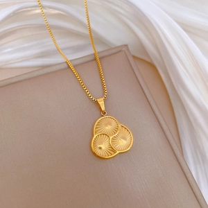 Detail of gold titanium steel necklace featuring sunburst textured triple circle pendant
