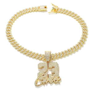 Macro shot of gold-plated iced-out number 23 pendant on a sparkling Cuban link chain