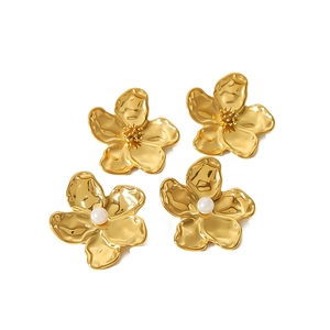 Golden flower petal earrings set with pearls and textured finish on a white background