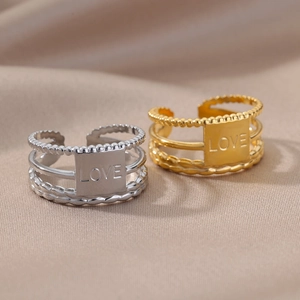 Detailed close-up of adjustable three-layer rings with engraved LOVE plate in gold and silver