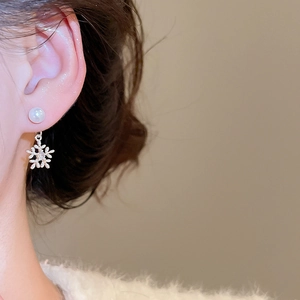 Elegante Schneeflocken-Ohrringe mit weißen Perlen und Zirkonia am Modell getragen