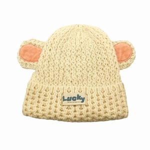 Détail d'un bonnet en maille beige avec oreilles d'animaux et étiquette Lucky