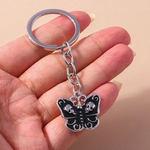 Detailed shot of Gothic butterfly keychain with black enamel and silver skull motifs