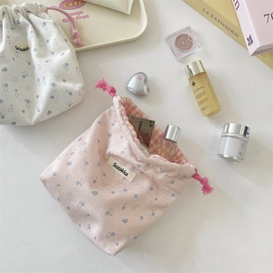 Floral drawstring pouches with pink checkered lining and elegant storage scene detail