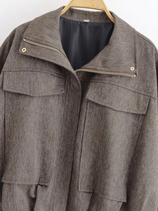 Detail of herringbone fabric bomber jacket featuring high collar and drawstring waist