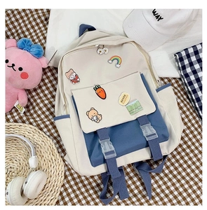Detail view of canvas backpack featuring cute cartoon pins and functional front pockets