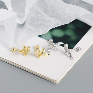 Macro shot of silver and gold dagger stud earrings with sparkling zircon accents