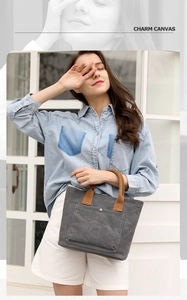 Stylish casual canvas tote bag for women with top handles and front pocket design.