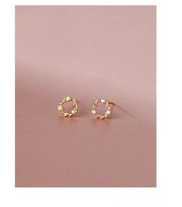 Macro shot of S925 sterling silver golden flower wreath earrings with white cubic zirconia