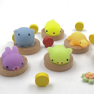 Close-up of colorful TPR animal squeeze toys on round wooden bases for stress relief