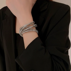 Detailed view of silver multi-layer snake bone textured bracelet on model's wrist