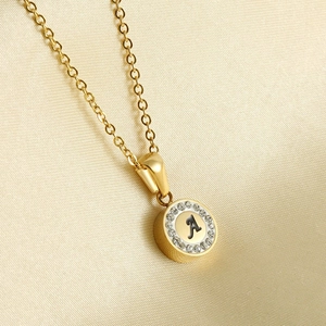 Macro shot of 18K gold plated necklace with round crystal-set letter A pendant