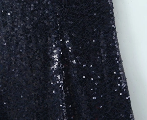 Macro shot of shimmering dark blue sequins on a sleeveless backless evening dress