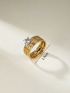Detailed view of triple-layered gold-plated ring with a sparkling cubic zirconia setting
