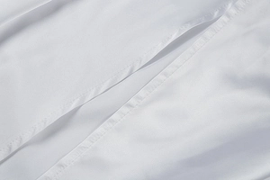 Close-up of precise stitching and premium texture on white off-shoulder evening dress
