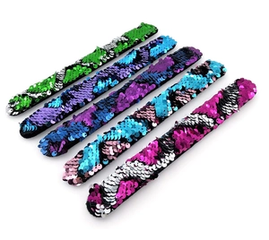 Dettaglio di paillettes reversibili colorate su braccialetti a scatto per bambini