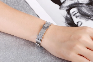 Dettaglio del bracciale a maglia argento con ciondoli a luna e fiocco di neve