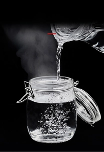 Close-up of heat-resistant glass storage jar showing steam and airtight metal buckle