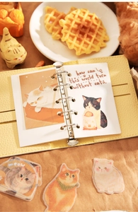 Vue détaillée d'autocollants de chats et carnet en similicuir jaune sur un bureau