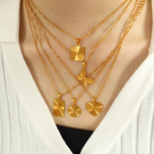 Golden titanium steel necklaces with heart and geometric pendants on female model