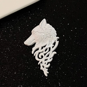 Vintage white wolf head brooch with tribal patterns on a black sparkling background