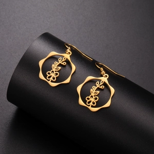 Macro detail of golden stainless steel flower earrings with intricate hollow-out floral design