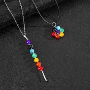 Macro detail of multi-colored stone flower and long strip pendants on beaded necklaces