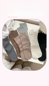 Close-up of ribbed cuffs on assorted earthy tone cotton mid-calf socks for women