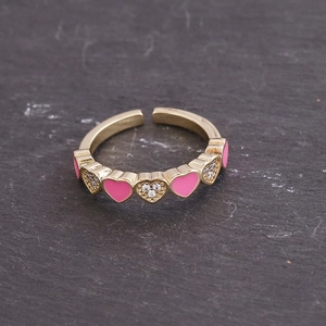 Detail of gold open ring featuring pink enamel hearts and sparkling zircon stones