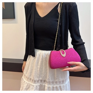 Pink glitter clutch bag with gold chain strap and rhinestone clasp shown with a stylish outfit