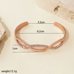 Rose gold stainless steel twisted bangle with white rhinestones in a minimalist design
