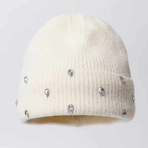 Close-up of ribbed knit beanie with sparkling crystal rhinestones on creamy white wool