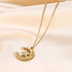 Golden moon and rhinestone star pendant necklace on a champagne satin background