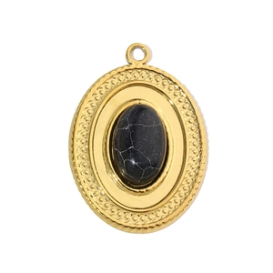 Macro detail of gold-plated oval pendant with natural black stone inlay and polished finish