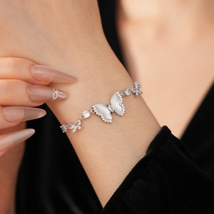Detailed macro shot of a resin butterfly zircon bracelet on a wrist with black background