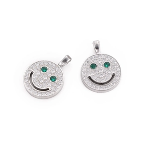 Macro shot of silver smiley pendants with white zircons and green gemstone eyes