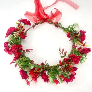 Close-up of red artificial sunflower crown with green leaves and a silk ribbon bow