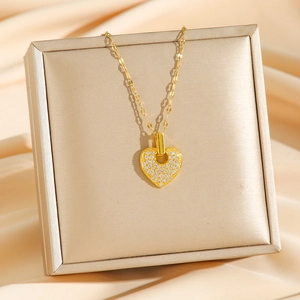 Golden heart pendant necklace with shimmering crystals on satin lining in a jewelry box