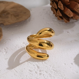 Dettaglio anello a spirale tripla placcato oro 18K su pietra bianca con decori autunnali