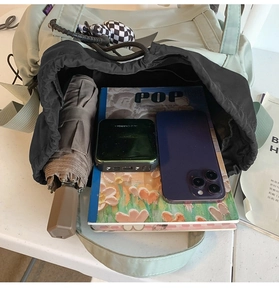 Top view of large capacity light green drawstring bag showing umbrella and phone storage