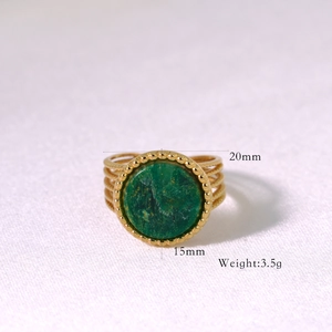 Detailed close-up of golden multi-layered ring with green stone and size dimensions