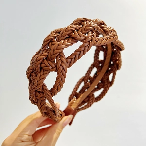 Detailed close-up of brown braided leather headband texture held in hand