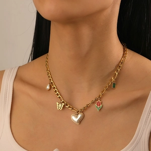 Close-up of gold stainless steel necklace with butterfly and tulip charms on model