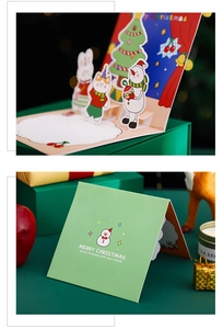 Close-up of 3D pop-up Christmas card with tree and rabbit figures on green cover