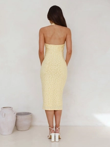 Back view of yellow lace halter dress showing the elegant backless cut and intricate texture