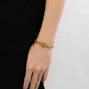 Detailed view of gold heart OT buckle bracelet worn on wrist with minimalist style