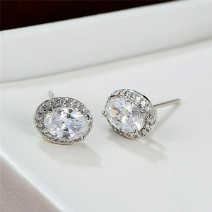 Elegant oval zircon stud earrings with sparkling halo set in polished silver metal