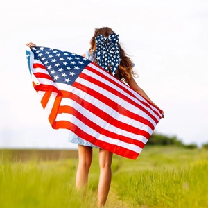Woman in nature wearing American flag pattern hair bow for Independence Day party