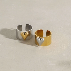 Macro detail of gold and silver heart rings with polished wide band adjustable design